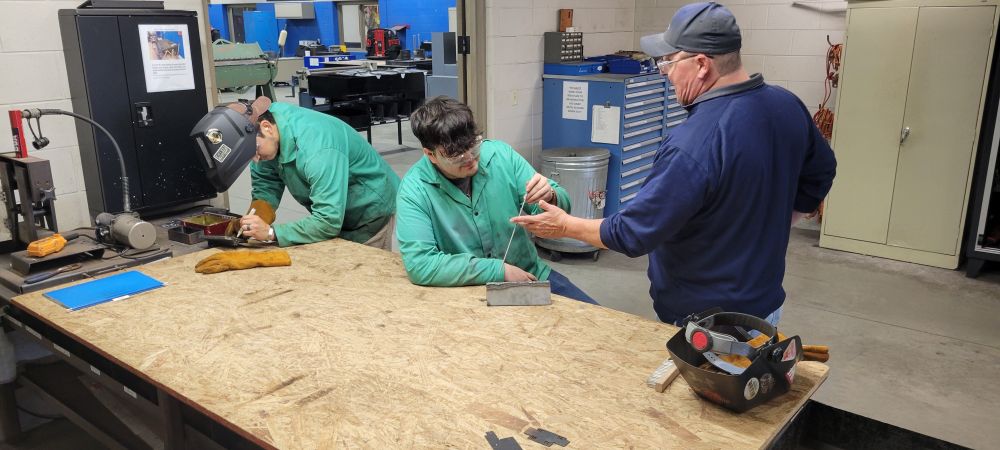 Dave Saunders assists Allan Doro, a Welding-Industrial student.